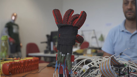 Ein futuristischer Handschuh im Vordergrund. 