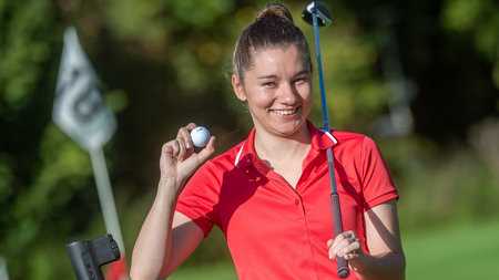 Frau mit Golfschläger in der Hand