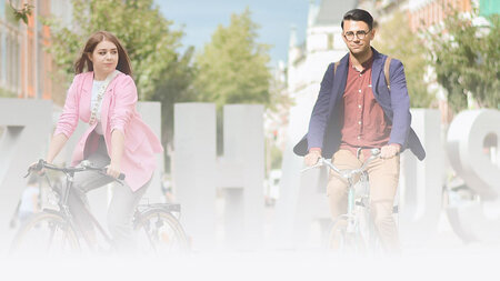 Eine junge Frau und ein junge Mann mit brille fahren Fahrrad.
