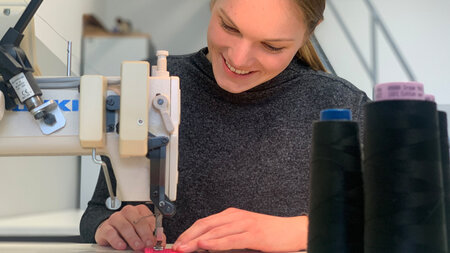 Junge Frau arbeitet an einer Nähmaschine