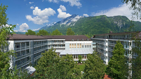 Gebäudeansicht, im Hintergrund Berge