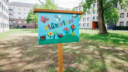 Ein Schild steht auf einer Wiese.