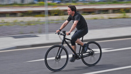 Ein Mann fährt mit einem Fahrrad auf einer Straße.