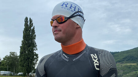 Ein Mann im Schwimmanzug, Badekappe und Schwimmbrille.