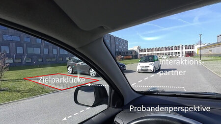 Fahrerperspektive mit Blick auf eine Parklücke sowie ein herannahendes Fahrzeug.