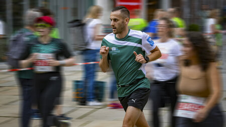 Ein Mann rennt an Läuferinnen und Läufern vorbei.