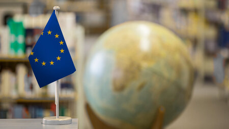 Eine Europaflagge vor einem Globus.