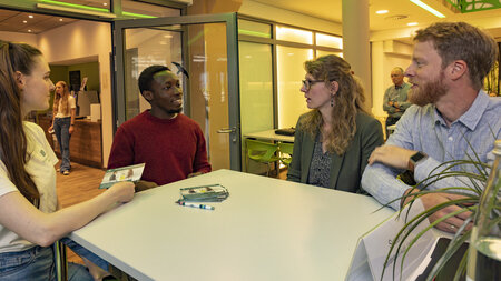 Ein Studentin und ein Student im Gespräch mit einer Mitarbeiterin und einem Mitarbeiter der TU Chemnitz.