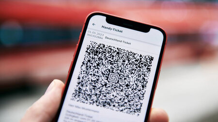 Auf dem Display eines Smartphones ist ein QR-Code zu sehen.