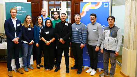 Menschen stehen vor einem Banner