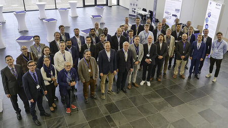 Mehrere Personen stehen hinter- und nebeneinander in einem Foyer.