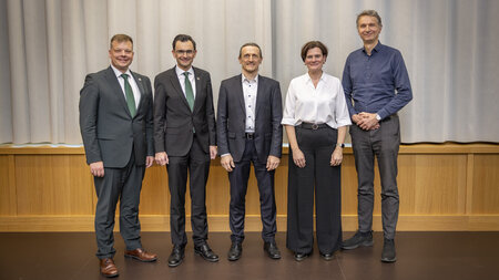 Vier Männer und eine Frau stehen nebeneinander.