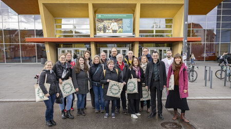 Mehrere Personen stehen vor einem Gebäude.