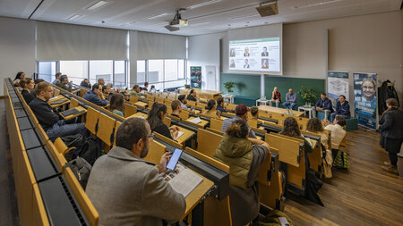 Mehre Personen sitzen in einem Hörsaal.