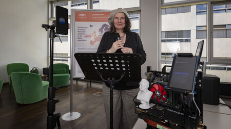 Eine Frau steht an einem Notenständer und einem Tablet.