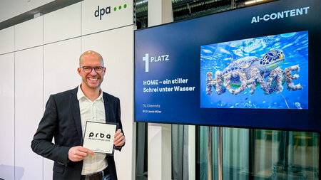 Ein Mann hält einen Preis in den Händen.