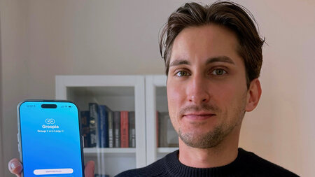 Ein Mann hält ein Handy in der Hand. 