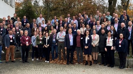 Mehrere Personen stehen neben einem Haus.