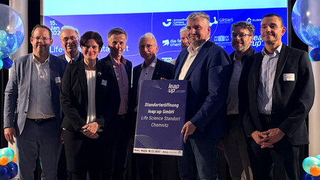 Mehrere Personen stehen vor einer Präsentation.