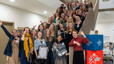 Mehrere Frauenb stehen auf einer Treppe in einem Gebäude. 