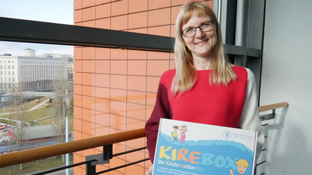 Eine Frau hält ein Schild in den Händen. 