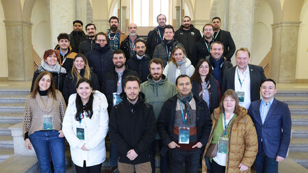 Mehrere Personen stehen im Foyer eines Geb�udes auf einer Treppe,