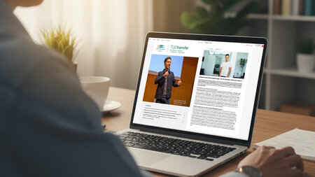 Eine Person blickt auf den Bildschirm eines Laptops, der auf einem Tisch steht.