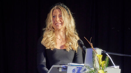 Eine Frau steht an einem Rednerpult.