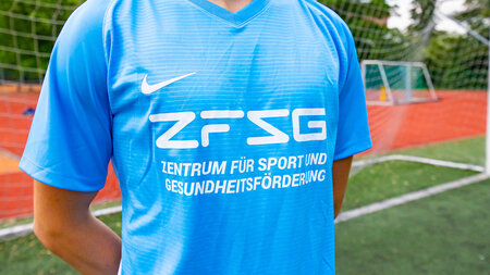 Eine Person trägt ein beschriftetes Sport-Shirt.