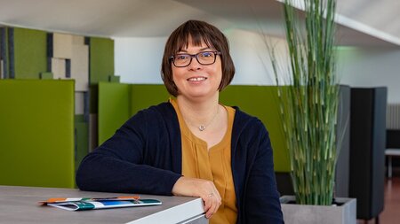 Frau steht vor einem Tisch