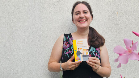 Eine Frau hält ein Buch in ihren Händen.