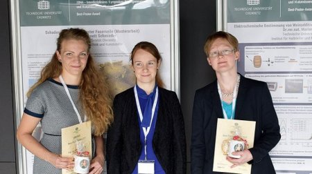 Drei Frauen stehen vor einer Posterwand.