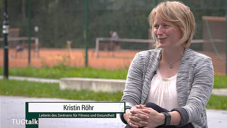 Junge Frau sitzt auf einem Stuhl.