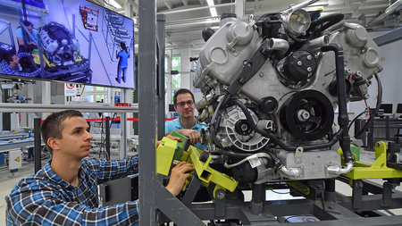 Zwei Männer arbeiten an einem Panamera-V8-Motor