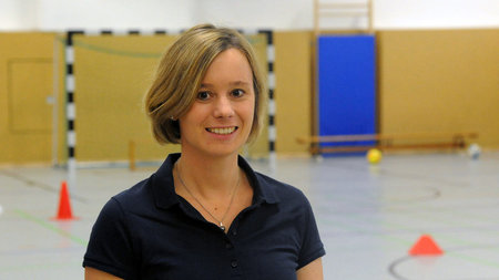 Portrait of Jun.-Prof. Anne Reimers in a gym