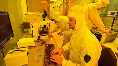 A man in a laboratory is working on a computer