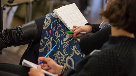 Frau mit Block auf dem Schoß.