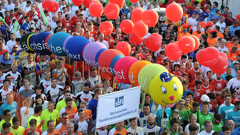 Bunte Raupe aus Textilien ist Maskottchen, das Läufer hochhalten