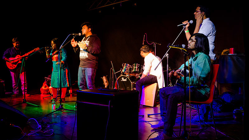 Indische Studierende musizieren auf der Mensabühne