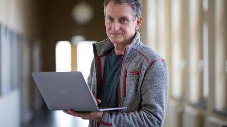 A men is holding a laptop.