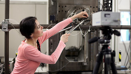 A young woman is working on a machine.