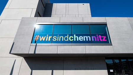A window of the Weinhold-Bau wears a sticker thats says #wirsindchemnitz.