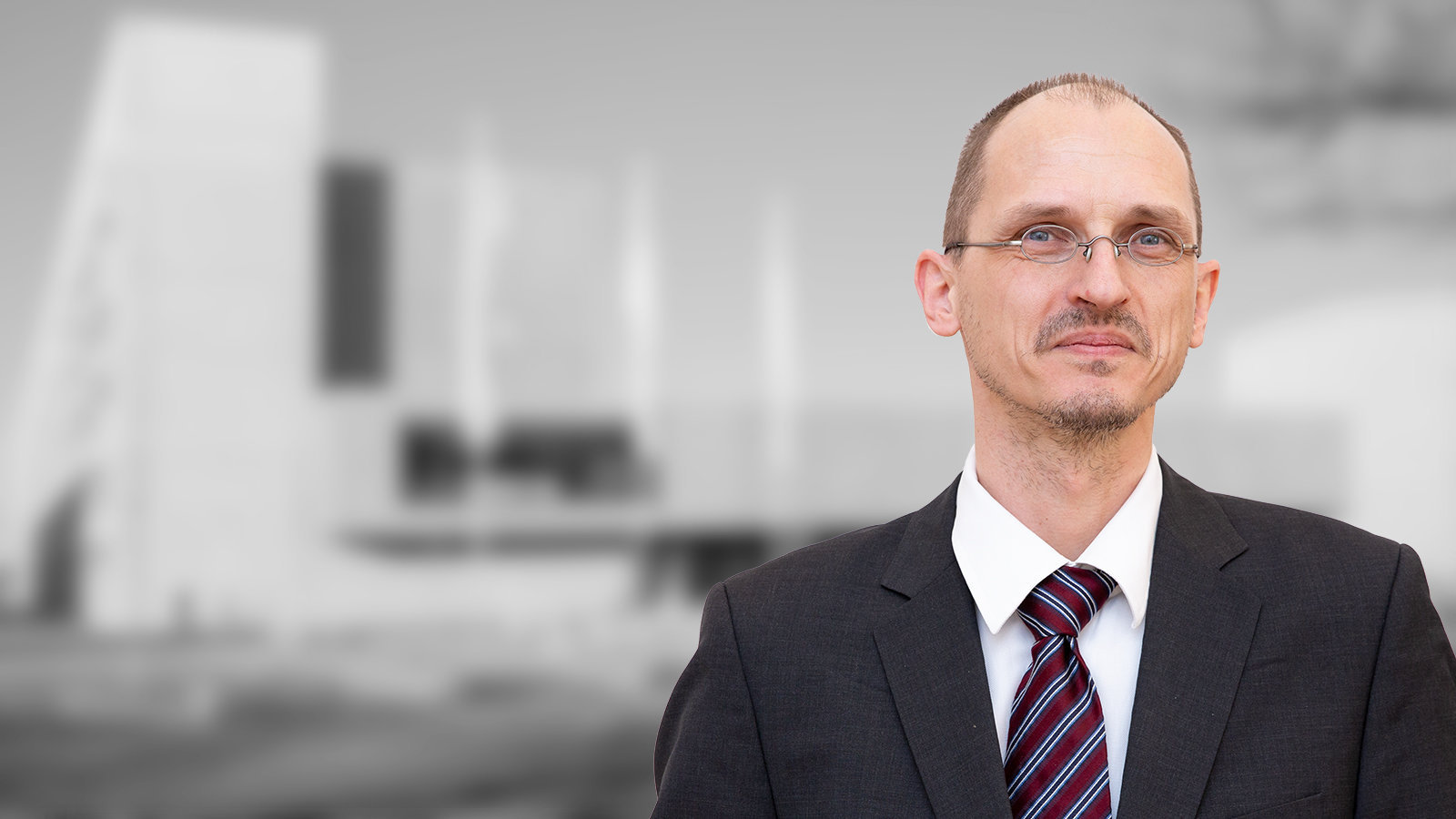 Ein Mann mittleren Alters mit Brille und Sakko.