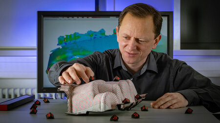 Ein Mann arbeitet an einem Bauteil in einem Labor.