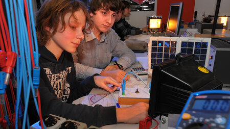 Zwei Kinder experimentieren im Labor mit Solarzellen.