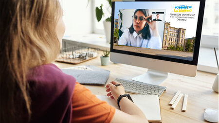 Eine junge Frau schaut auf einen Laptopbilschrim. Dort läuft eine Onlineveranstaltung.