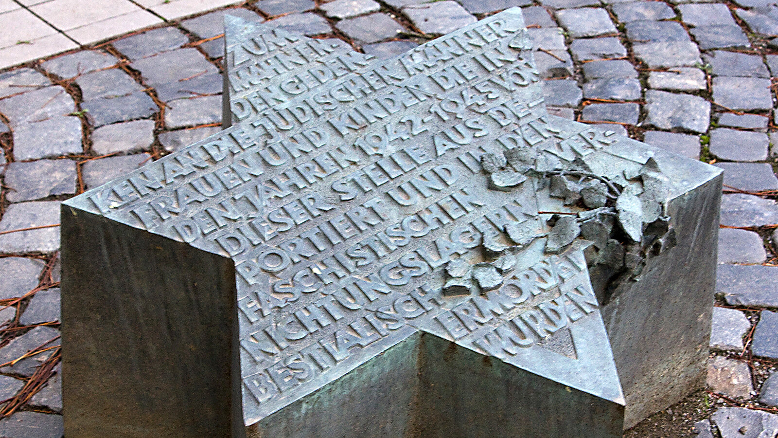 Als Davidstern gestalteter Gedenkstein mit Innschrift.