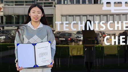 A young woman holding a certificate.