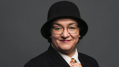 Porträt einer Frau, die einen schwarzen Hut trägt.