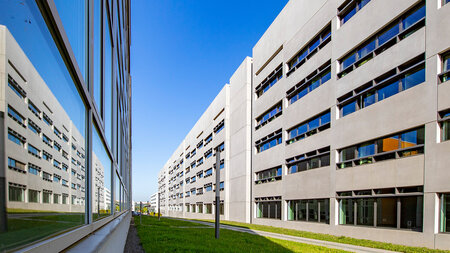 Ein Gebäude spiegelt sich in der Fassade eines benachbarten Gebäudes.